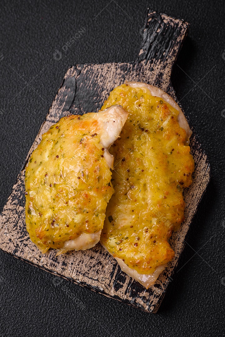 Deliciosa carne frita com mostarda Dijon com sal, especiarias e ervas sobre fundo escuro de concreto