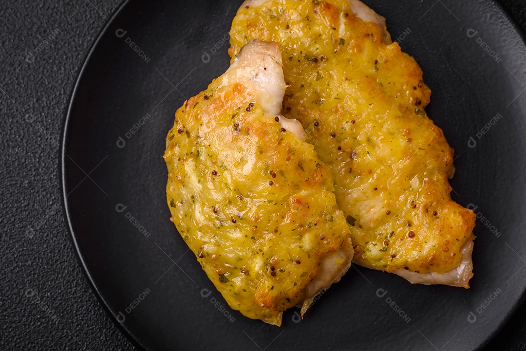 Deliciosa carne frita com mostarda Dijon com sal, especiarias e ervas sobre fundo escuro de concreto