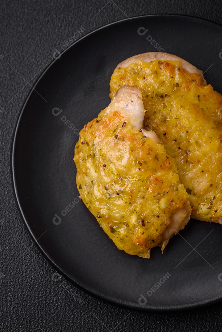 Deliciosa carne frita com mostarda Dijon com sal, especiarias e ervas sobre fundo escuro de concreto