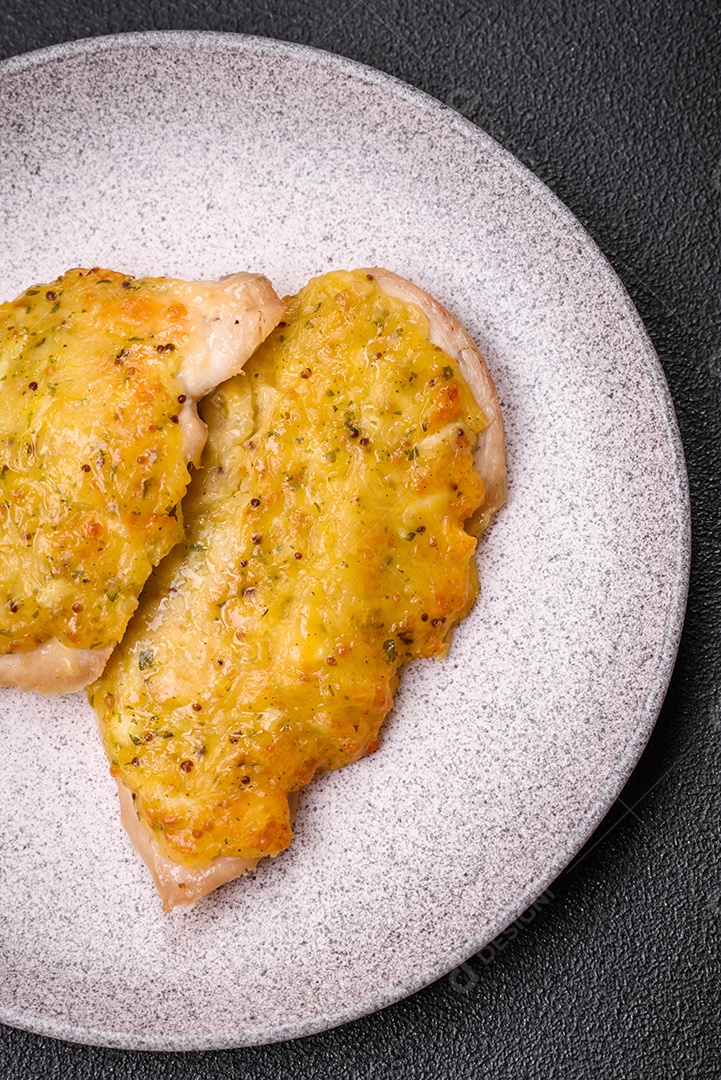Deliciosa carne frita com mostarda Dijon com sal, especiarias e ervas sobre fundo escuro de concreto