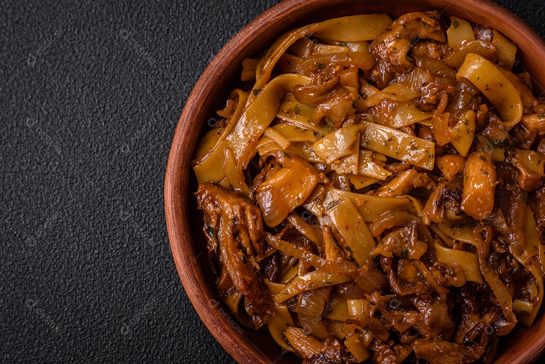 Delicioso prato de udon asiático com legumes, cogumelos, sal e especiarias numa placa cerâmica sobre um fundo escuro de concreto