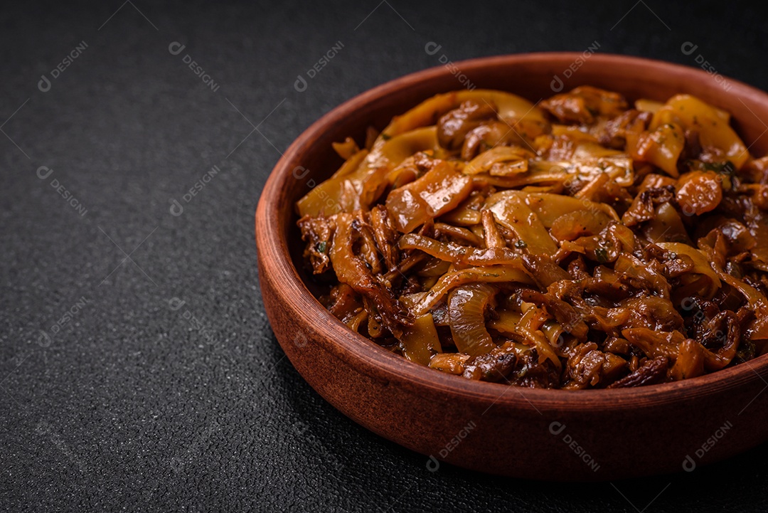 Delicioso prato de udon asiático com legumes, cogumelos, sal e especiarias numa placa cerâmica sobre um fundo escuro de concreto