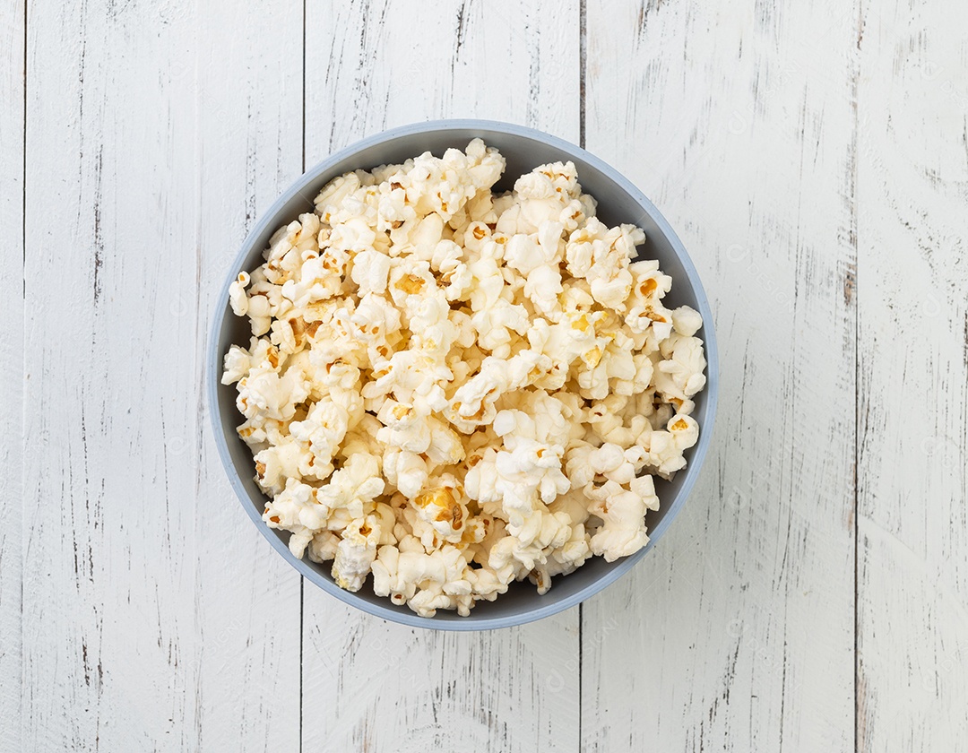 Pipoca dentro de uma tigela sobre fundo de madeira