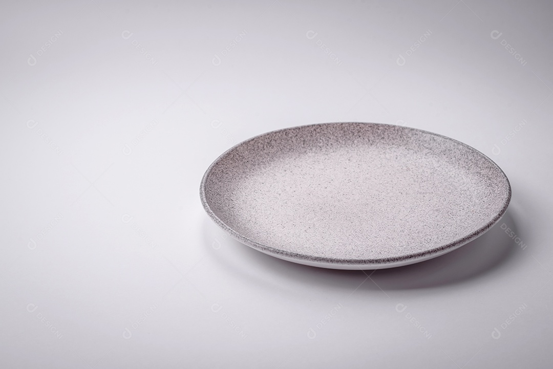 Placa cerâmica redonda vazia sobre um fundo liso, flatley Utensílios de cozinha na cozinha de casa
