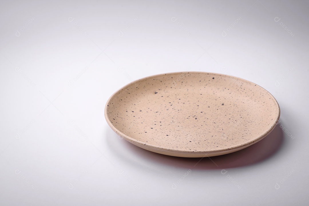 Placa cerâmica redonda vazia sobre um fundo liso, flatley Utensílios de cozinha na cozinha de casa