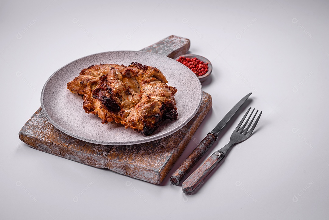 Delicioso frango crocante fresco grelhado com sal, especiarias e ervas. Prato de carne grelhada