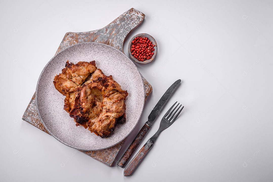 Delicioso frango crocante fresco grelhado com sal, especiarias e ervas. Prato de carne grelhada