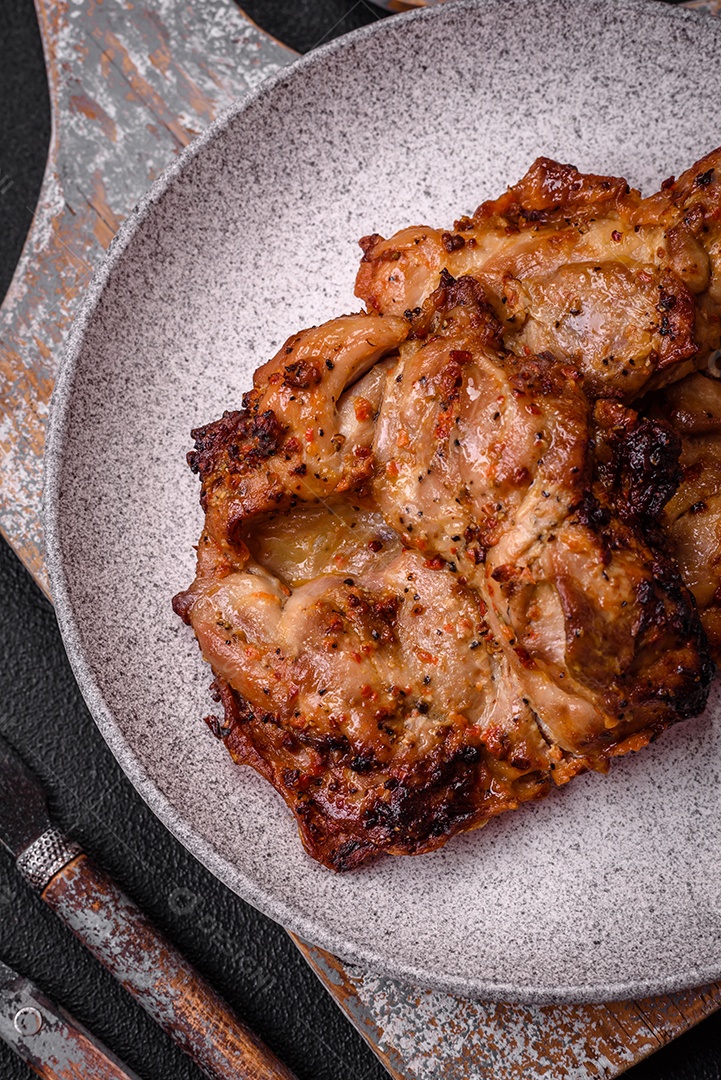 Delicioso frango crocante fresco grelhado com sal, especiarias e ervas. Prato de carne grelhada