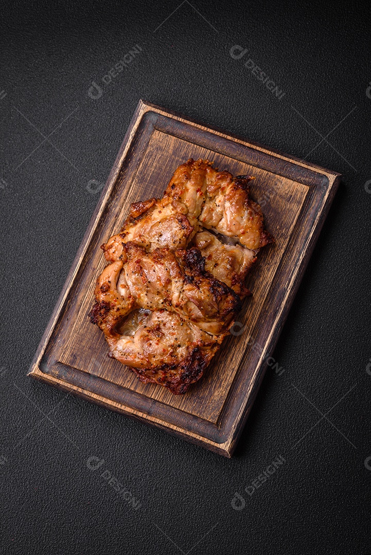 Delicioso frango crocante fresco grelhado com sal, especiarias e ervas. Prato de carne grelhada