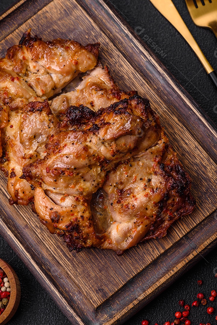 Delicioso frango crocante fresco grelhado com sal, especiarias e ervas. Prato de carne grelhada