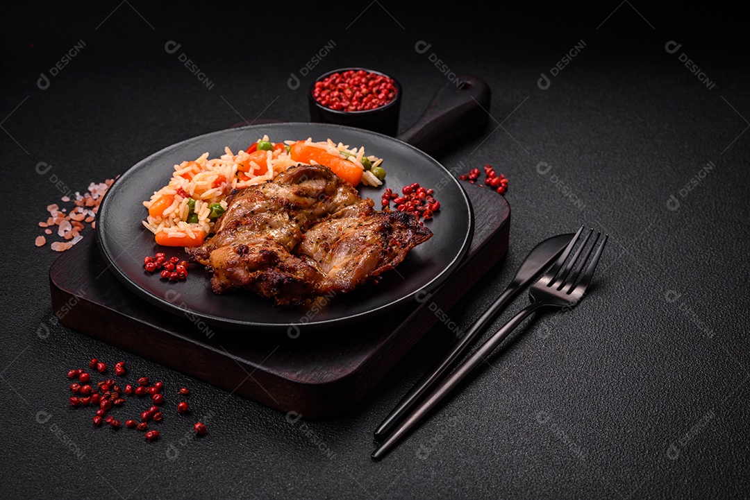 Delicioso arroz cozido com legumes, pimentas, ervilhas verdes, sal, especiarias e ervas sobre um fundo escuro de concreto