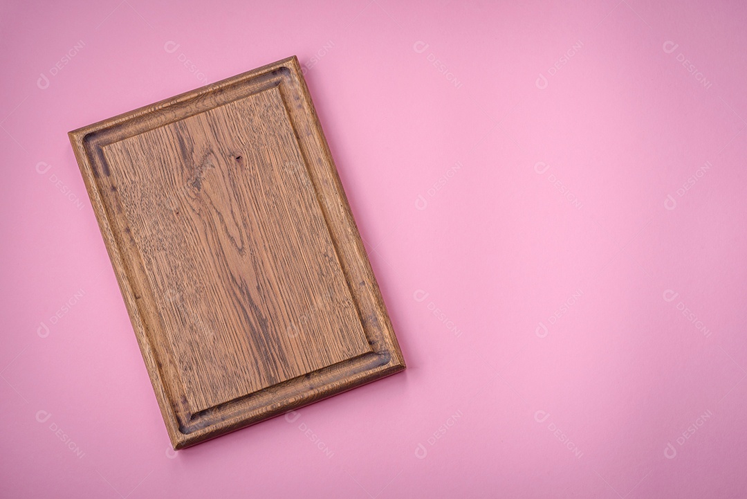 Tábua de corte retangular de madeira vazia em um fundo liso, flatley. Utensílios de cozinha na cozinha de casa