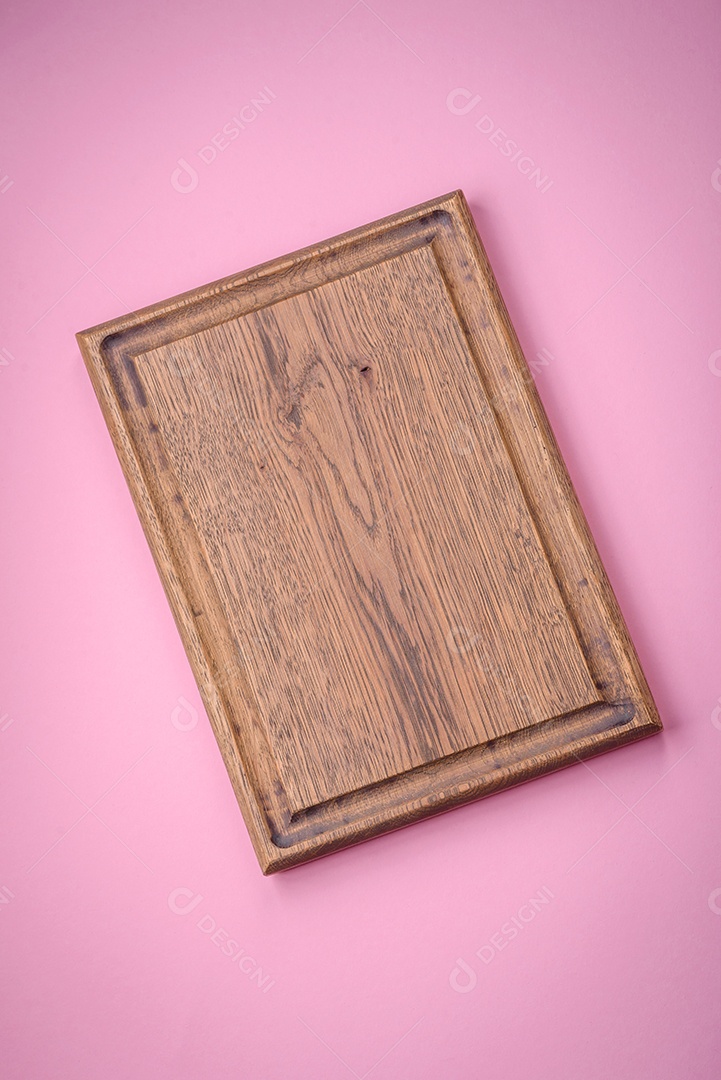 Tábua de corte retangular de madeira vazia em um fundo liso, flatley. Utensílios de cozinha na cozinha de casa