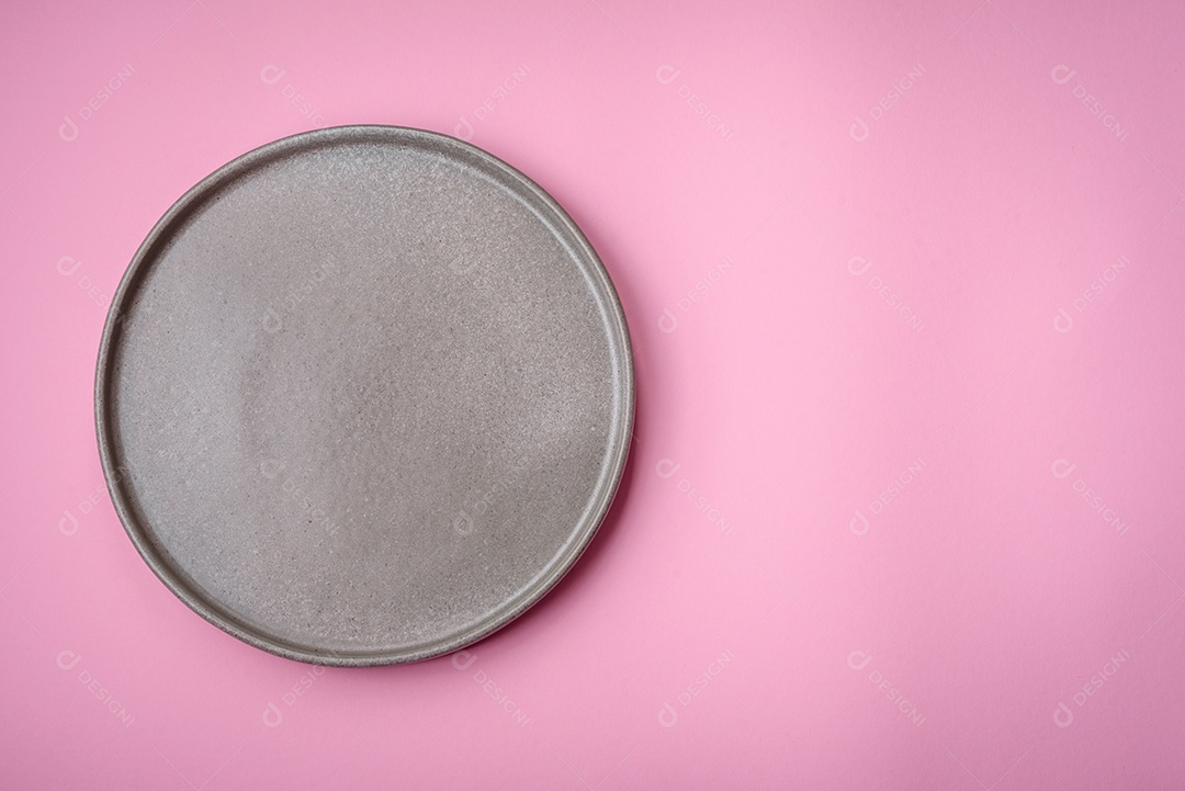 Placa cerâmica redonda vazia sobre um fundo liso, flatley com espaço de cópia. Utensílios de cozinha na cozinha de casa