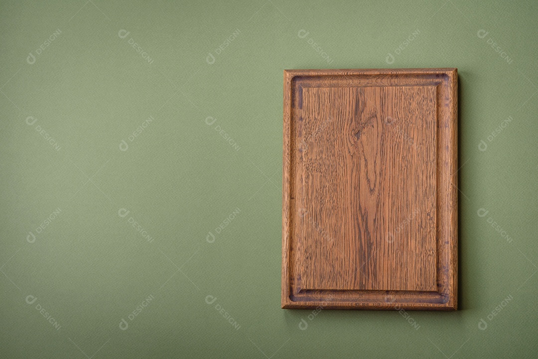 Tábua de corte retangular de madeira vazia em um fundo liso. Utensílios de cozinha na cozinha de casa