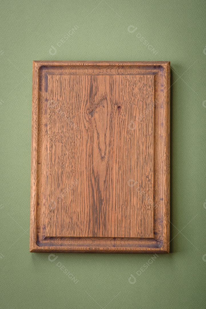 Tábua de corte retangular de madeira vazia em um fundo liso. Utensílios de cozinha na cozinha de casa