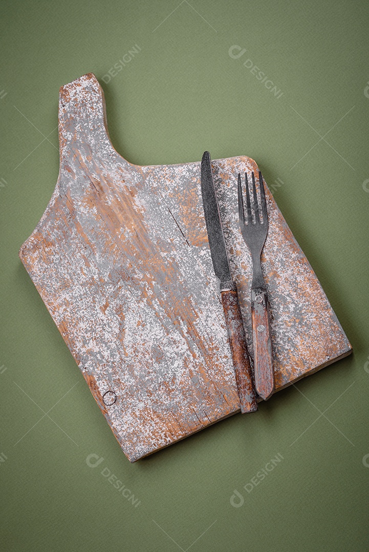 Tábua de corte retangular de madeira vazia em um fundo liso. Utensílios de cozinha na cozinha de casa