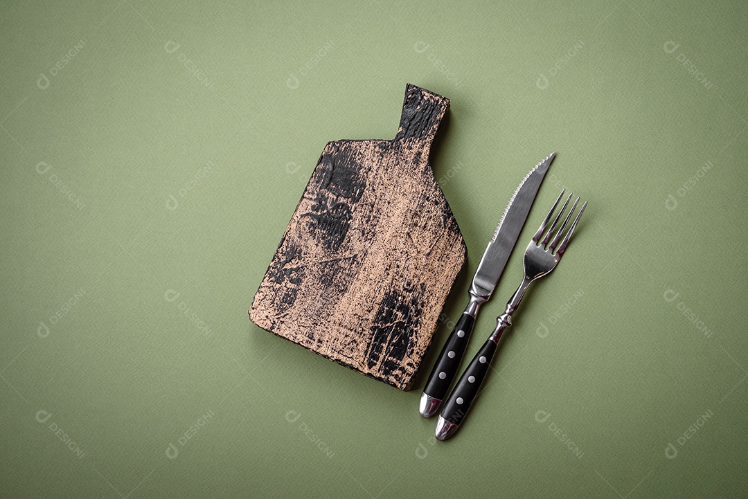 Tábua de corte retangular de madeira vazia em um fundo liso. Utensílios de cozinha na cozinha de casa