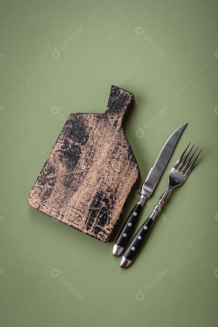 Tábua de corte retangular de madeira vazia em um fundo liso. Utensílios de cozinha na cozinha de casa