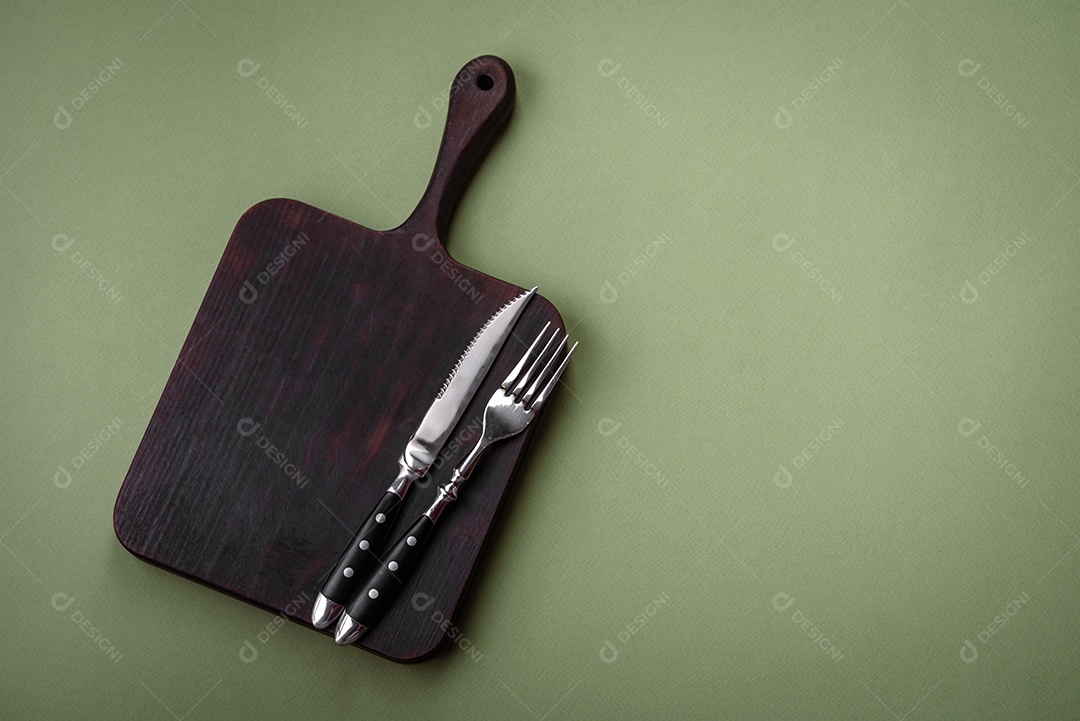 Placa cerâmica redonda vazia sobre um fundo liso. Utensílios de cozinha na cozinha de casa