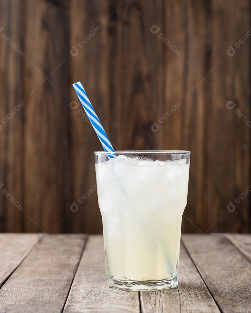 Refrigerante de li em um copo com gelo e canudo sobre a mesa de madeira