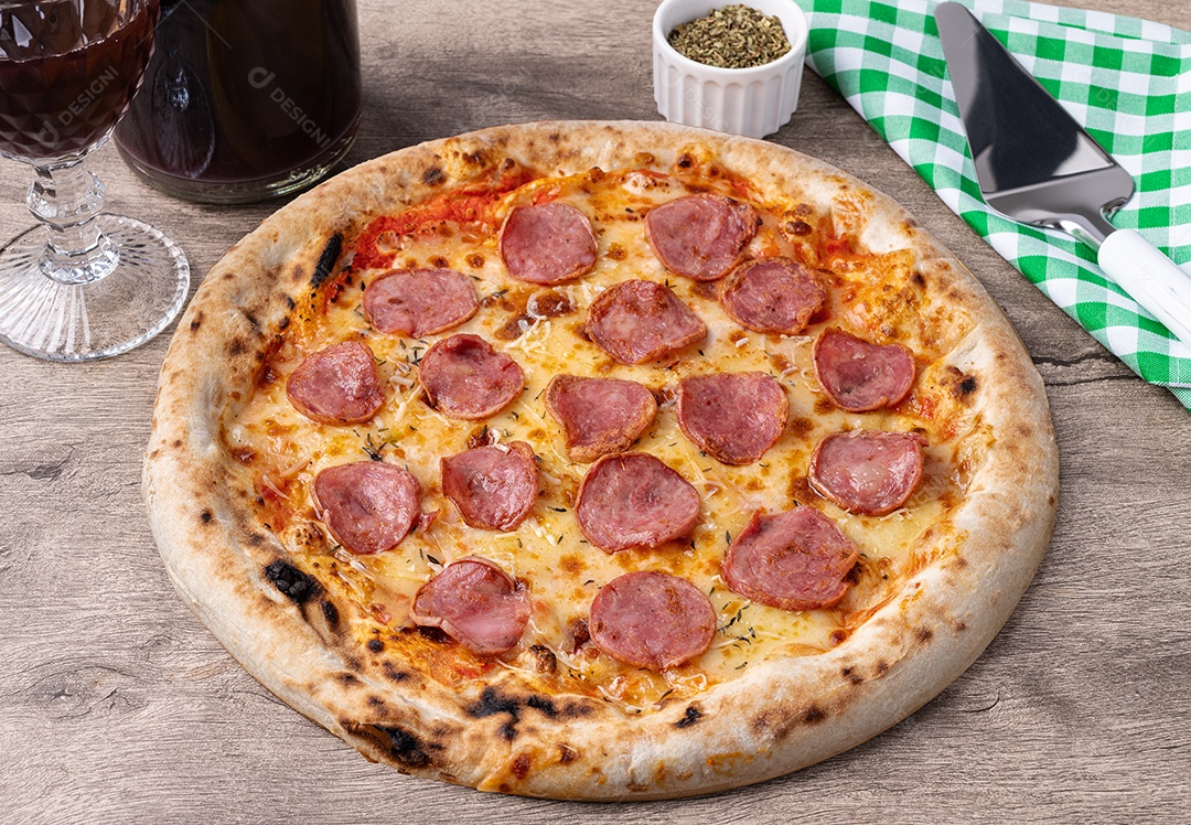 Pizza de calabresa oregano com vinho ao lado sobre mesa