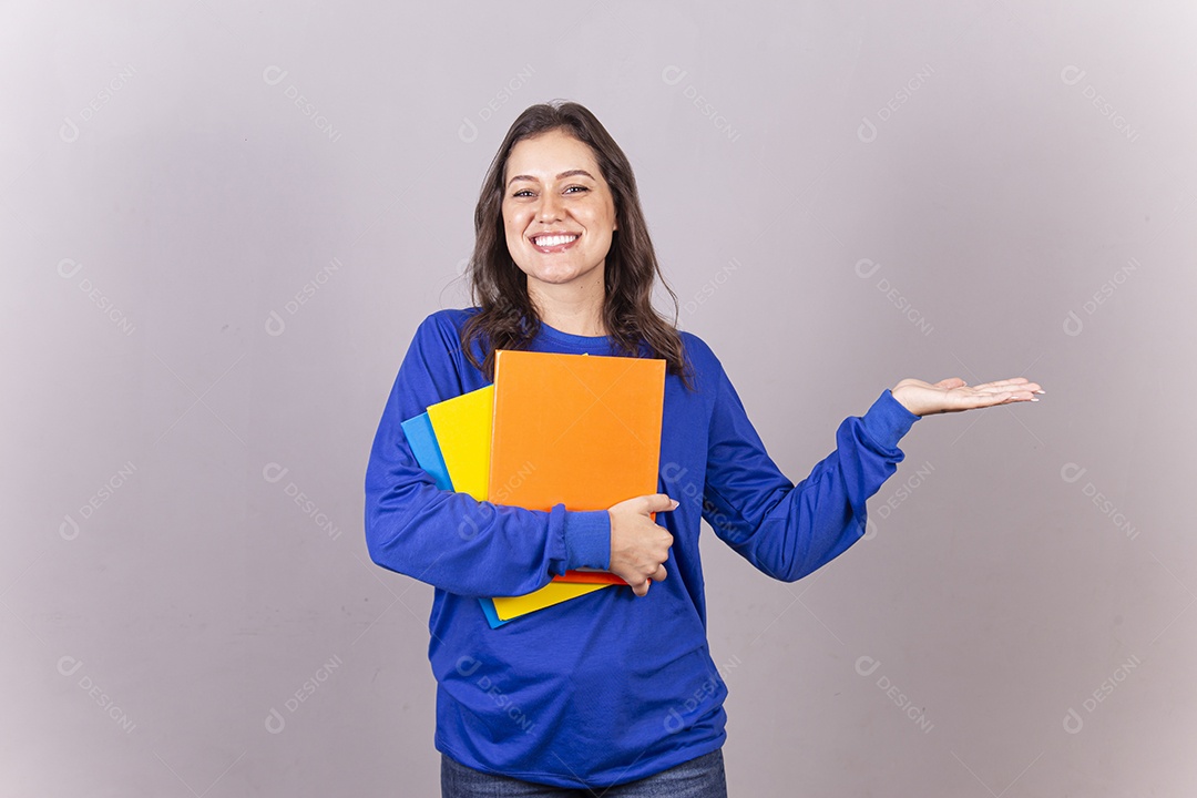 Jovem mulher vestida com moletom azul segurando livros.