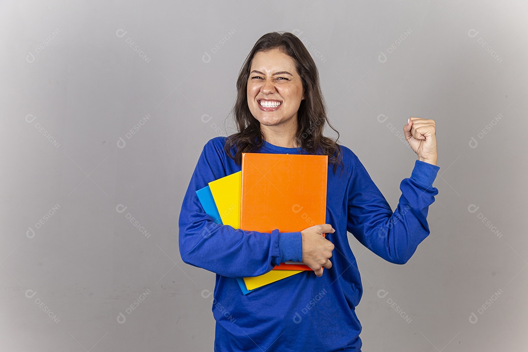 Jovem mulher vestida com moletom azul segurando livros.