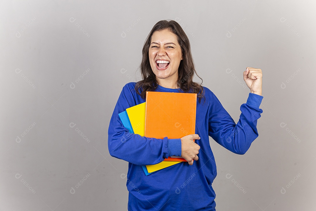 Jovem mulher vestida com moletom azul segurando livros.
