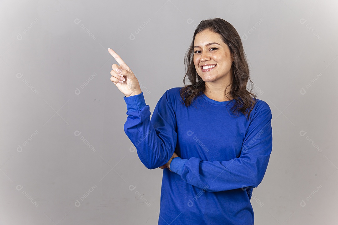 Linda jovem mulher vestida com moletom azul apontando para o lado