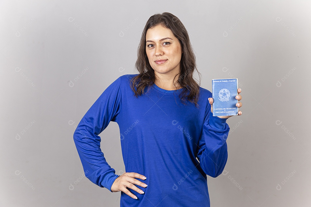 Linda jovem mulher vestida com moletom azul mostrando carteira de trabalho.