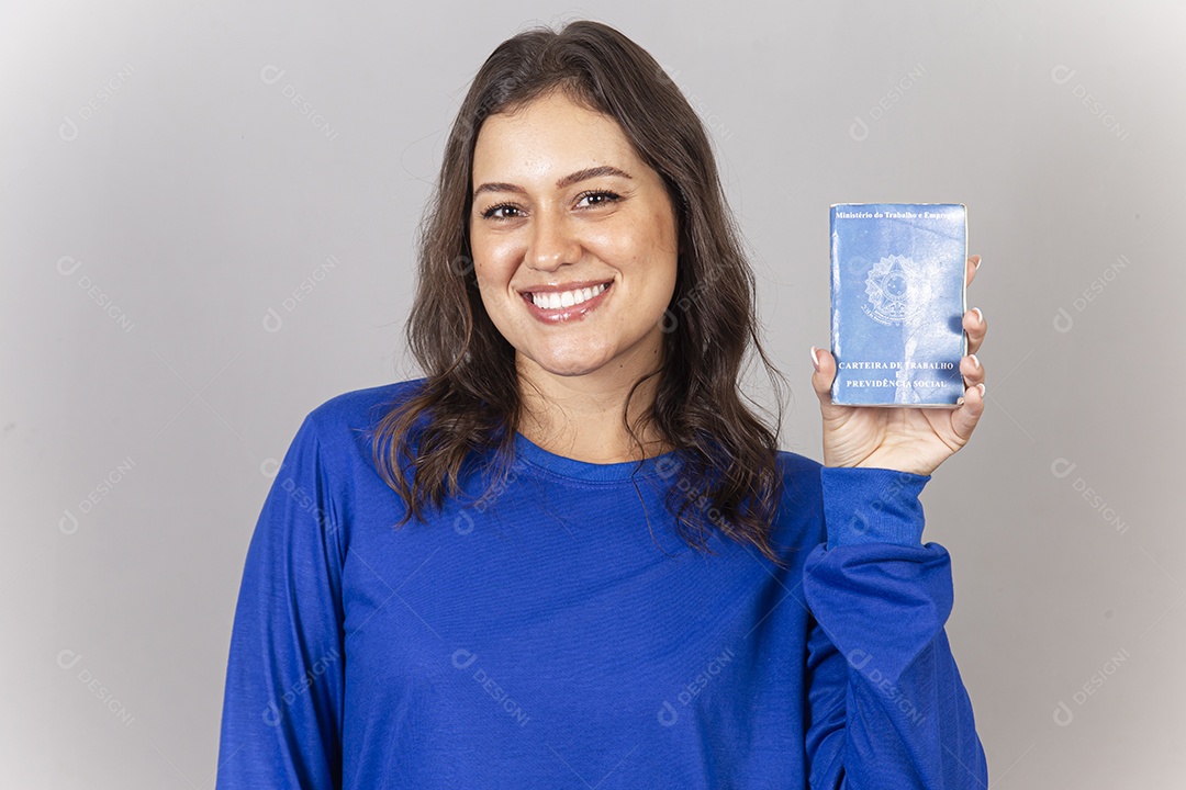 Linda jovem mulher vestida com moletom azul mostrando carteira de trabalho.