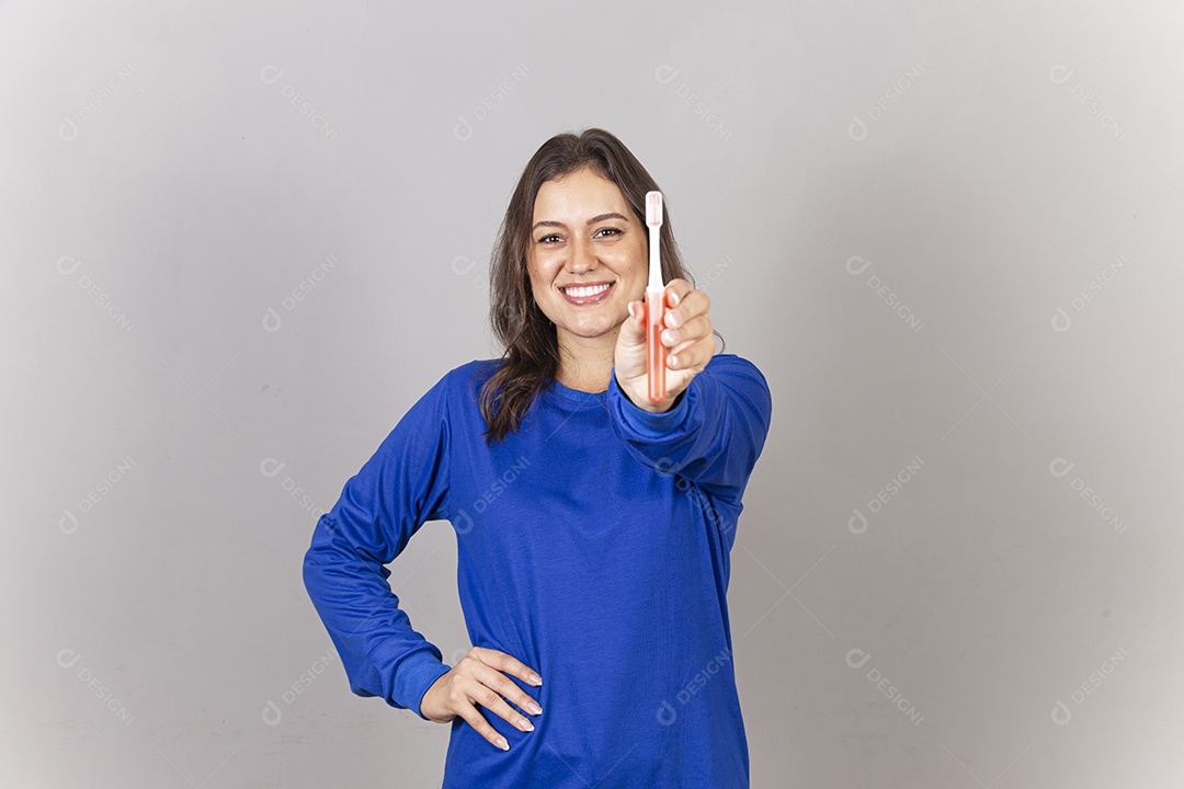 Linda mulher sorridente mostrando escova dental na mão.