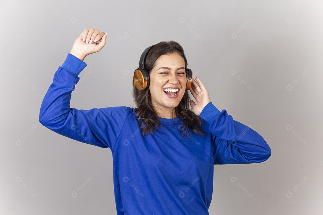 Linda jovem mulher vestida com moletom azul usando fone de ouvido.