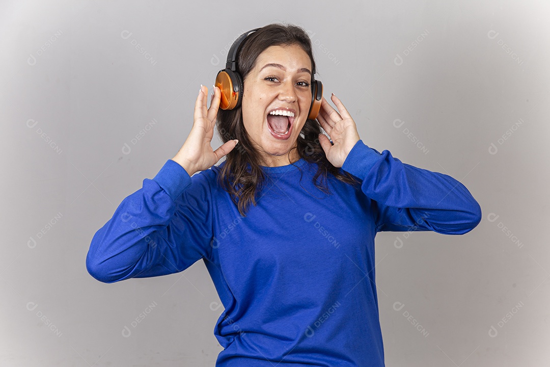 Linda jovem mulher vestida com moletom azul usando fone de ouvido.