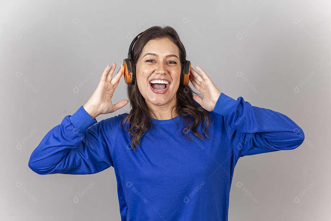 Linda jovem mulher vestida com moletom azul usando fone de ouvido.