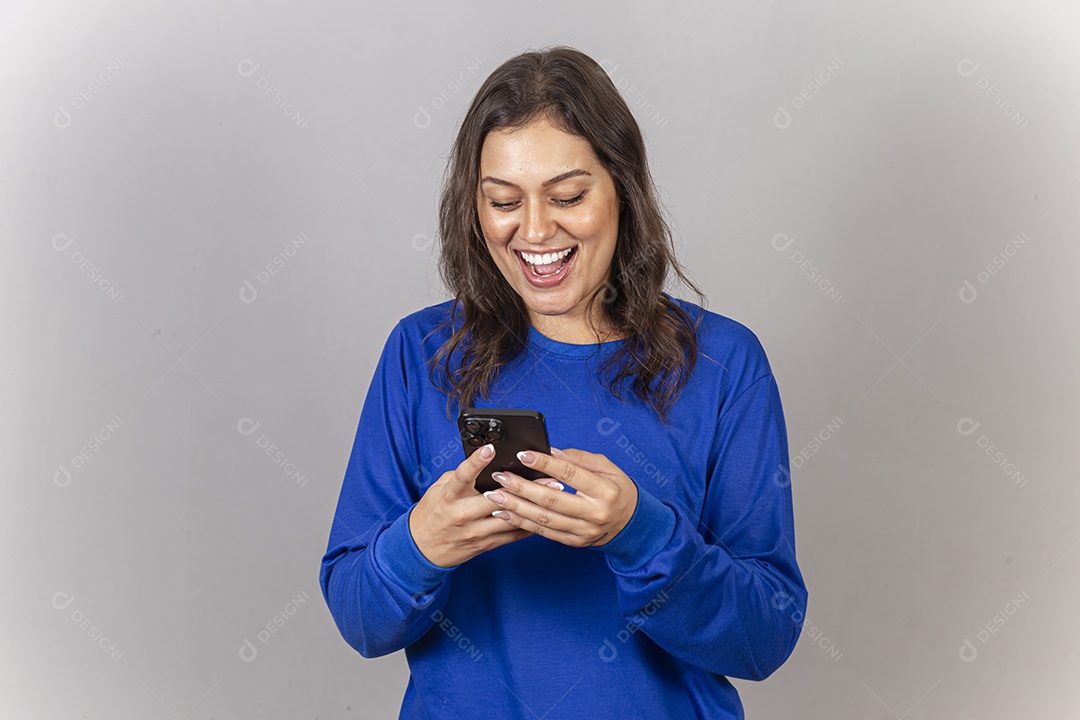 Linda mulher sorridente com celular na mão vestida com moletom azul.