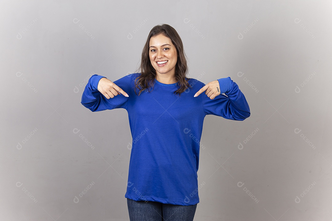 Linda jovem mulher vestida com moletom azul apontando para a roupa.