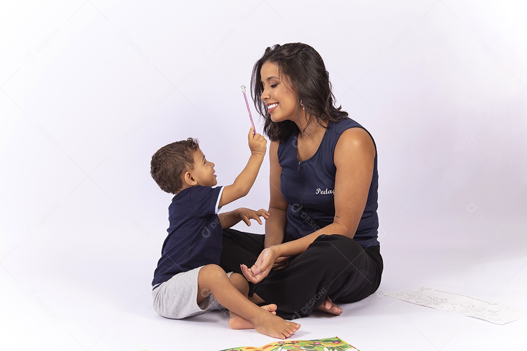 Criança brincando com a professora sobre um fundo isolado branco.