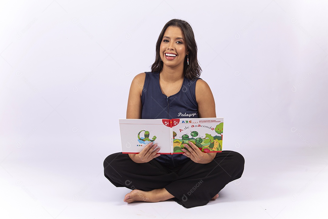 Professora sentada com um livro sobre um fundo isolado branco.