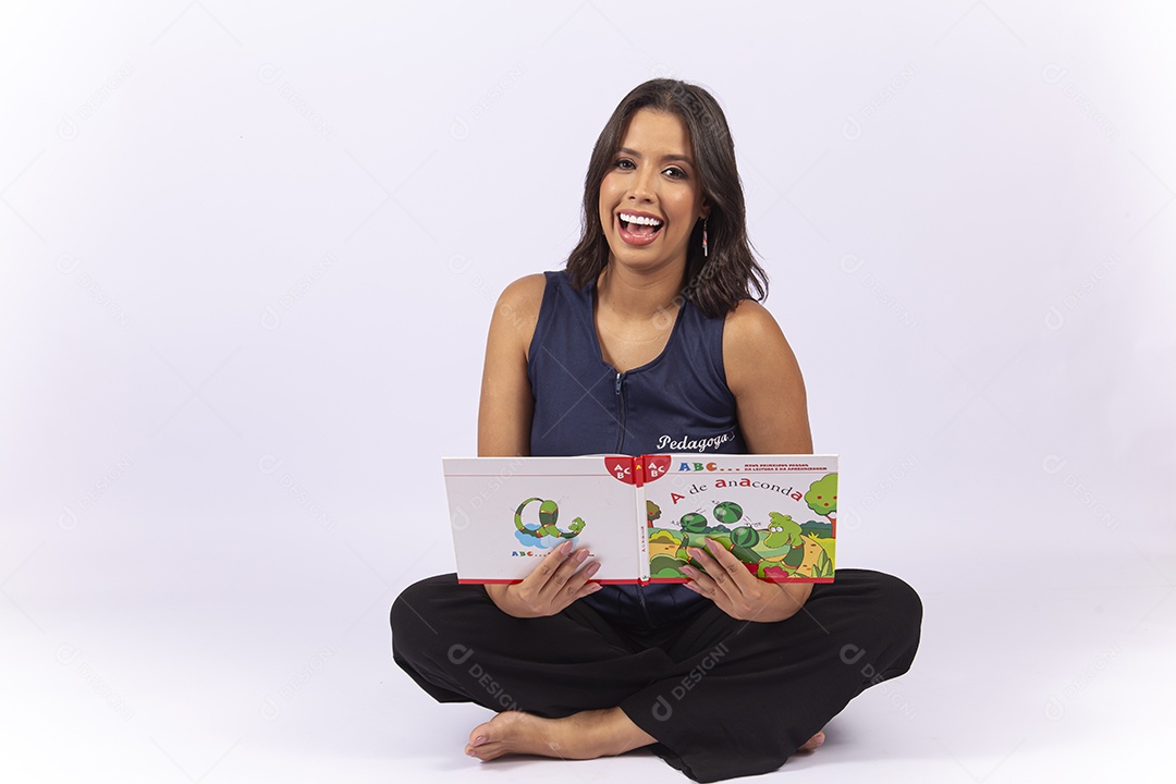 Professora sentada com um livro sobre um fundo isolado branco.