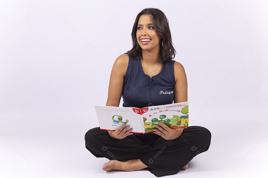 Professora sentada com um livro sobre um fundo isolado branco.