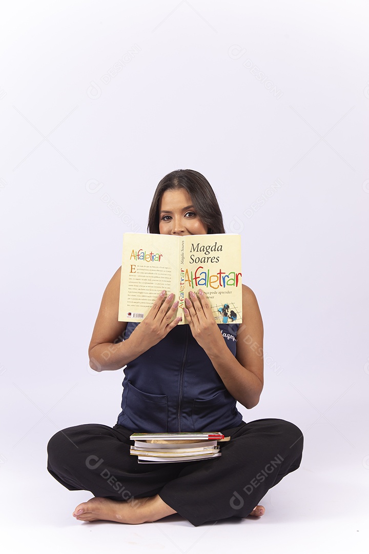 Professora sentada com um livro sobre um fundo isolado branco.