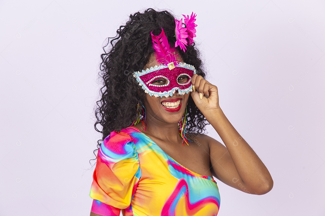 Linda mulher cabelo cacheado usando máscara fantasia de carnaval.
