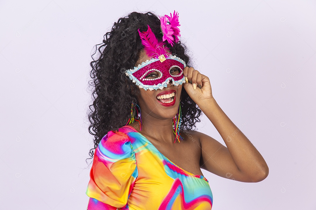Linda mulher cabelo cacheado usando máscara fantasia de carnaval.