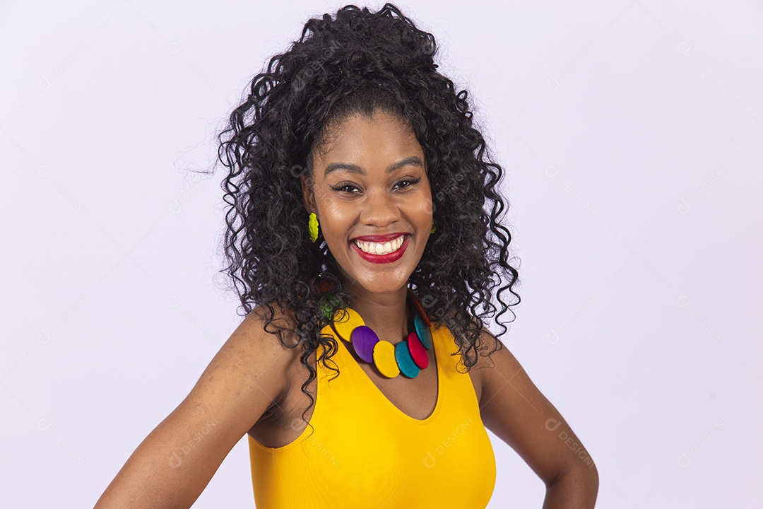 Linda mulher de cabelo cacheado vestida de blusa amarela sobre um fundo isolado branco.