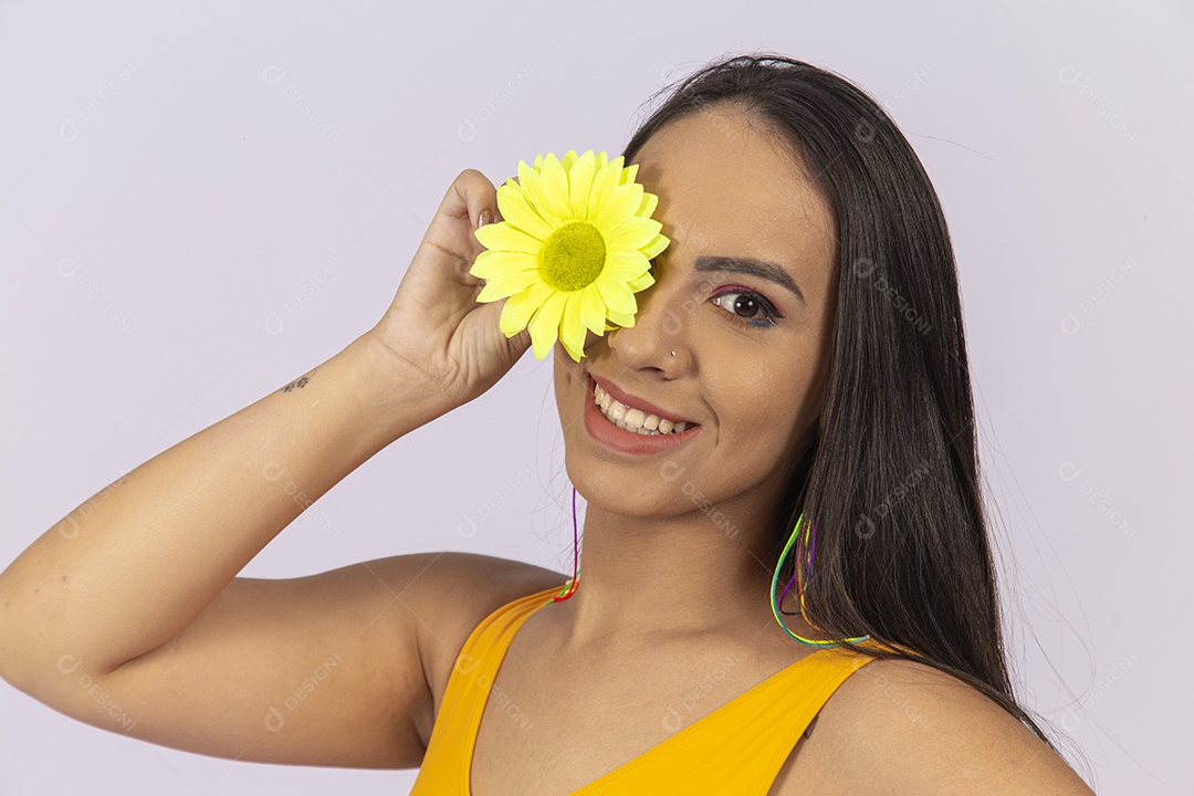Linda mulher segurando uma flor amarela sobre o olho.
