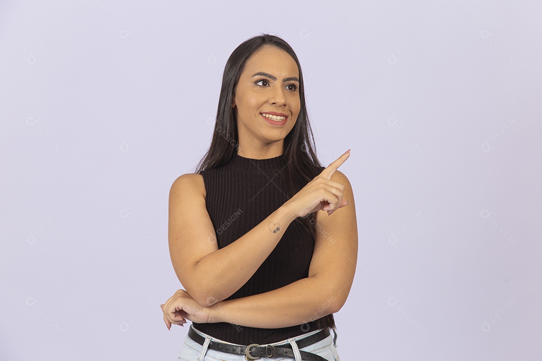 Linda mulher apontando para o lado vestida de blusa preta sobre um fundo isolado branco.