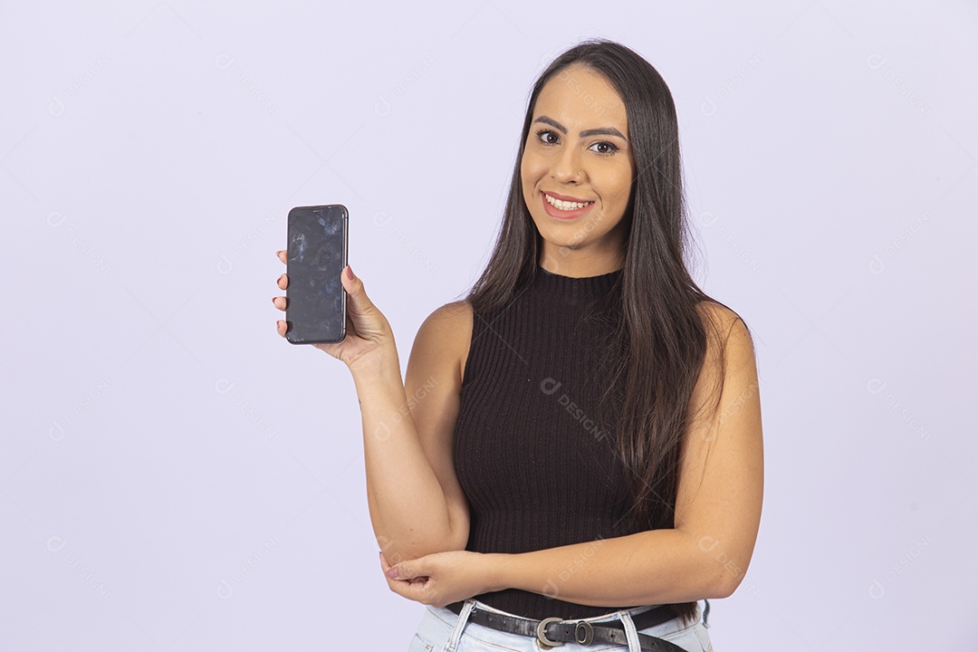 Linda mulher segurando celular vestida de blusa preta sobre um fundo isolado branco.
