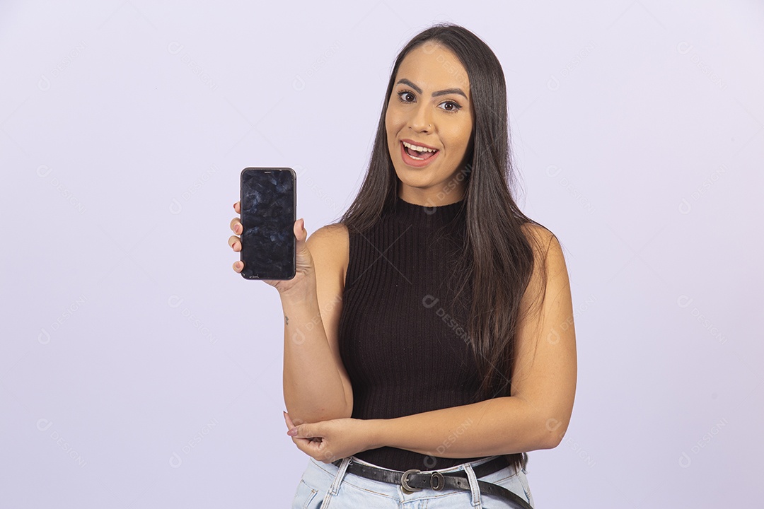 Linda mulher segurando celular vestida de blusa preta sobre um fundo isolado branco.